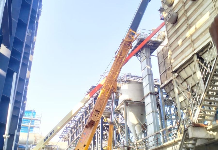 XCMG telescopic crane working alongside a JLG boom lift inside a chemical plant