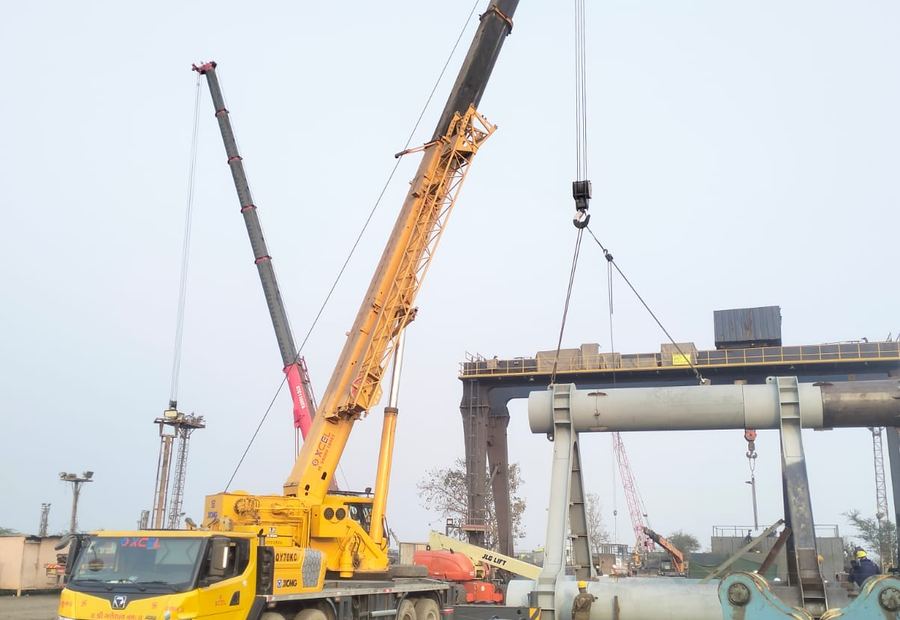 XCMG 70 tonne telescopic crane lifting a fabricated steel section at a yard in Bharuch